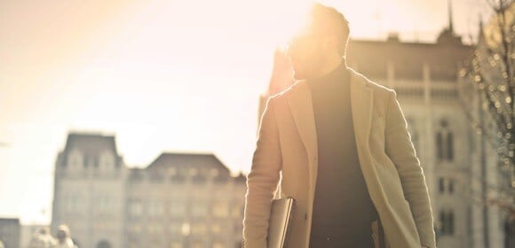 Man walking with sun behind him