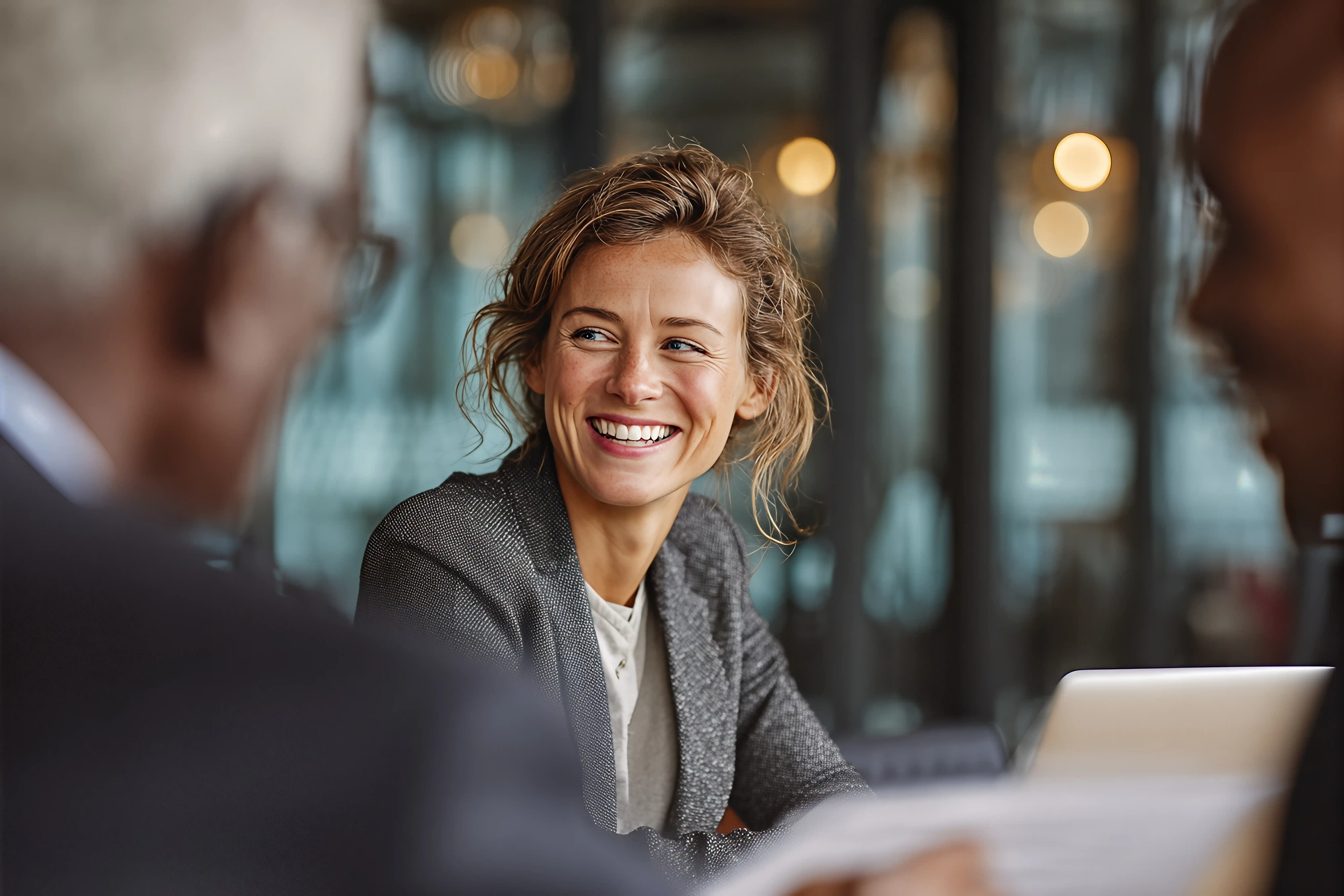 Smiling professional woman engaged in a business discussion during a meeting with colleagues.